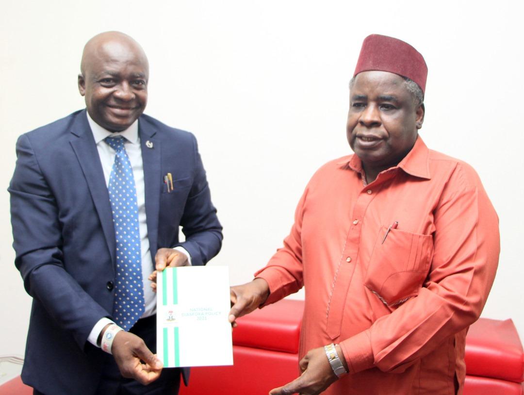 (R) Dr Sule Yakubu Bassi, Secretary to NIDCOM presenting a copy of the National Diaspora Policy to (L) Mr Olumide Ogunlade, Editor-In-Chief Acclaim Nigeria Magazine, in Abuja.